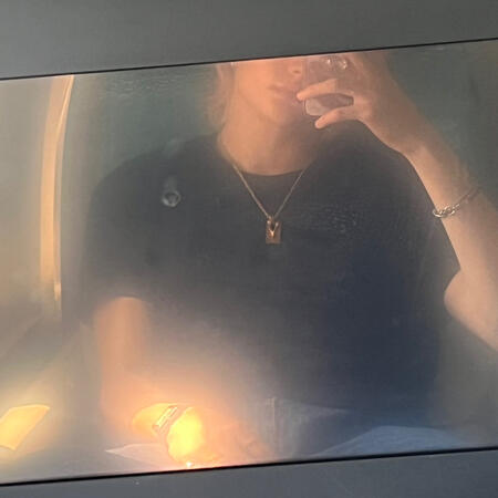 hwang hyunjin's reflection in a turned off plane monitor, his face isn't visible